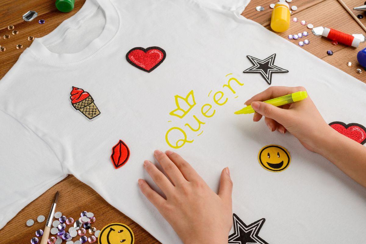 A lady designing t-shirt with the help of different tools and materials.