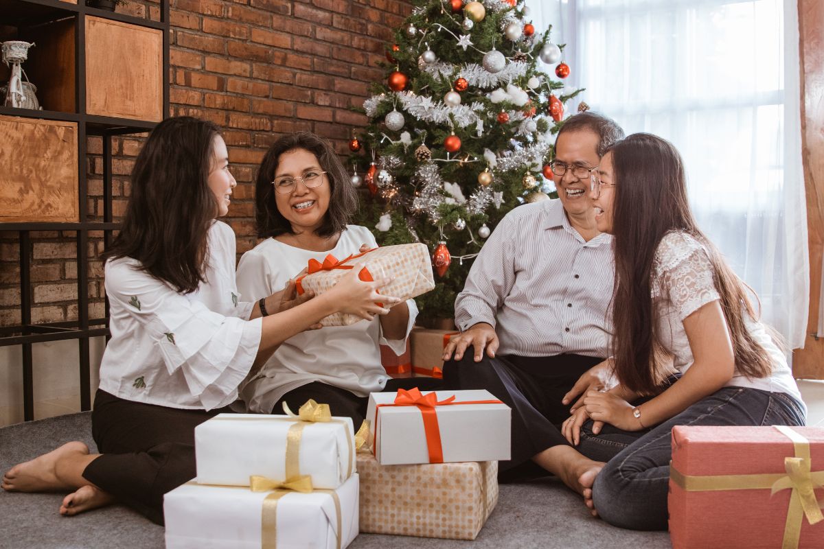 A lady giving Christmas gift to her grand father.