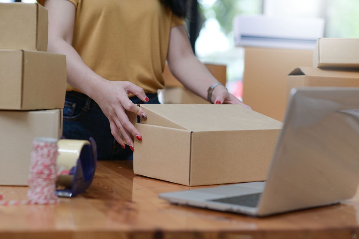 A lady packing some of her print on demand products to test their true value in market.