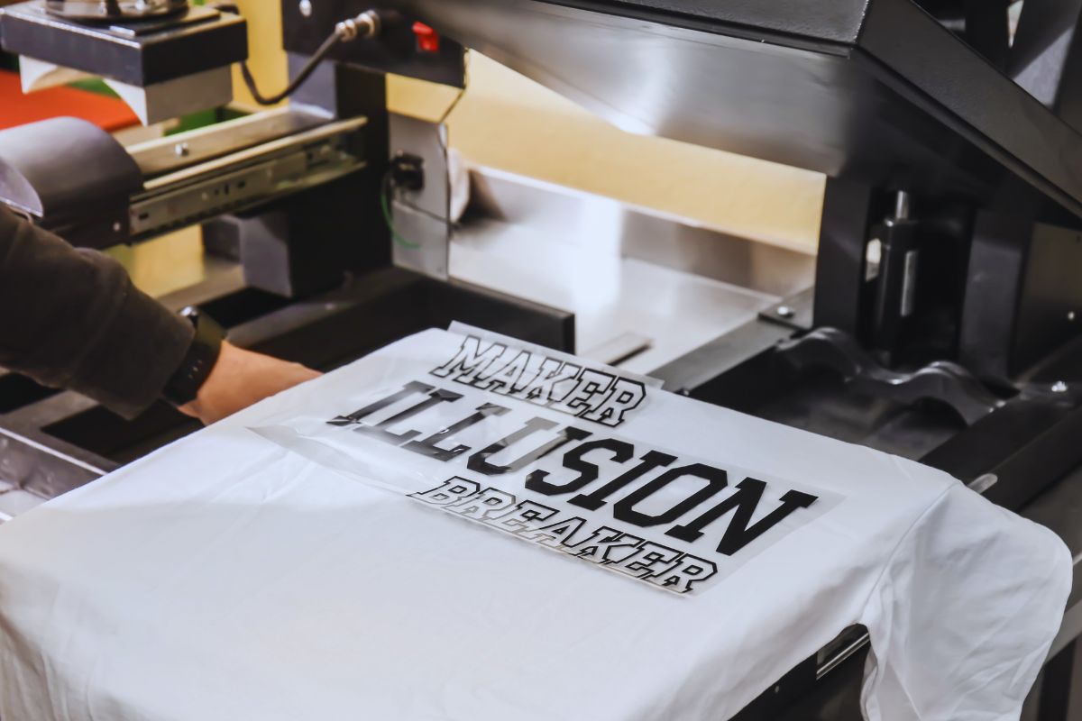 A man adding a design to a t shirt