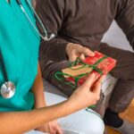 A patient gives a nurse a Christmas present.