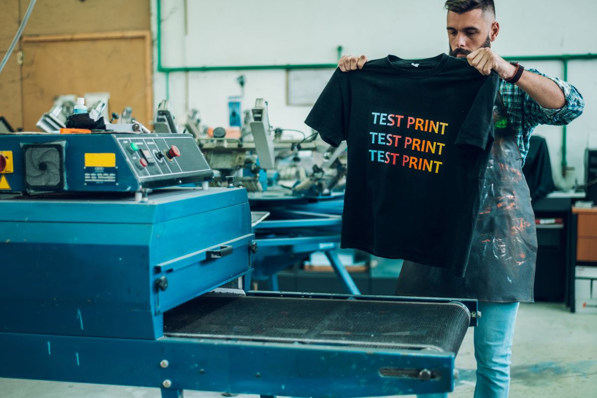 A person testing the print color and quality after the printing process on t-shirt.