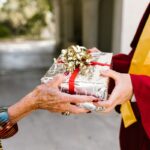 A student receiving Christmas gift from his teacher.