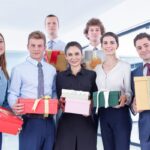 Employees with their Christmas presents standing together, capturing a photo.