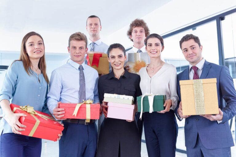 Employees with their Christmas presents standing together, capturing a photo.