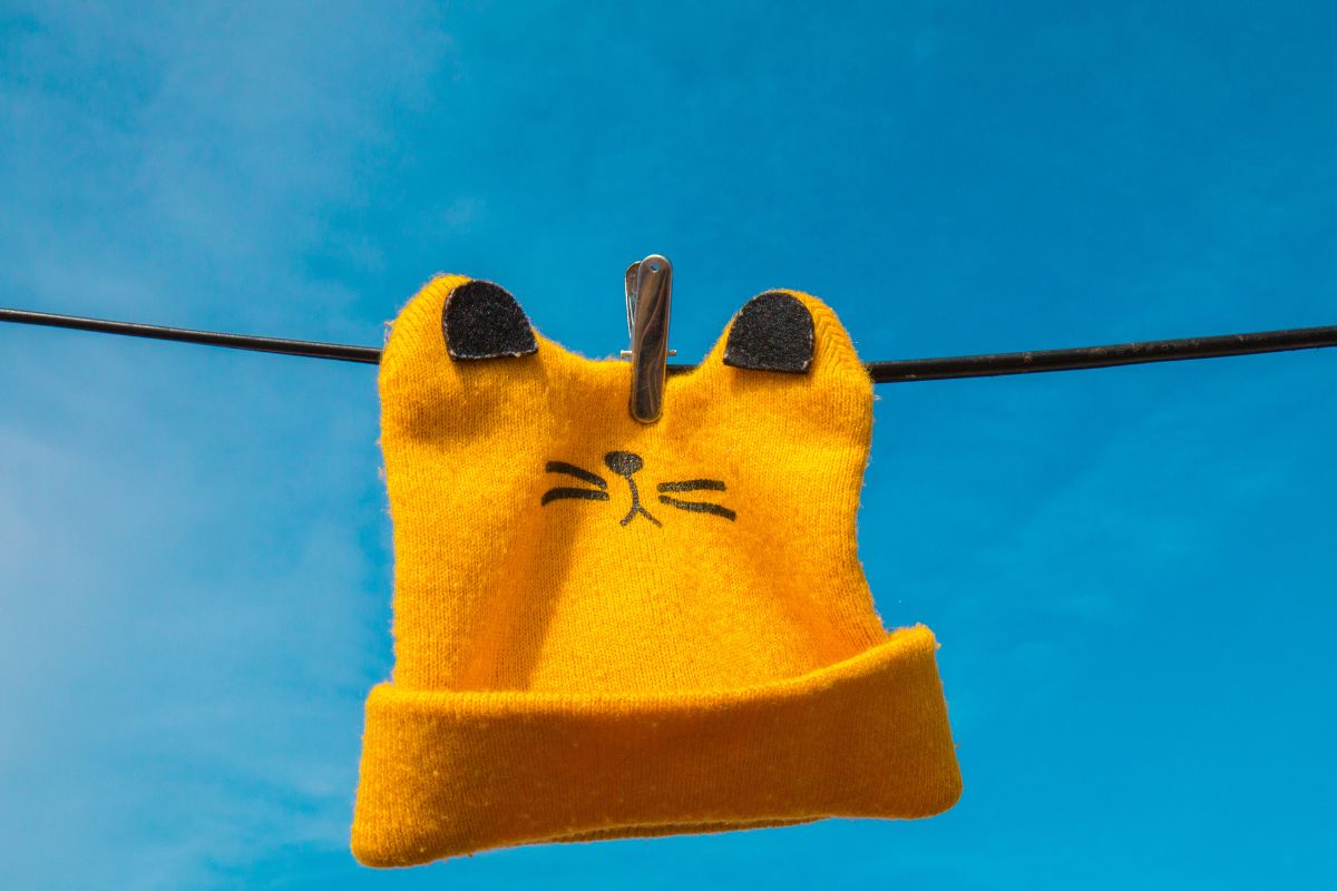 A beanie kept on clothesline for drying.