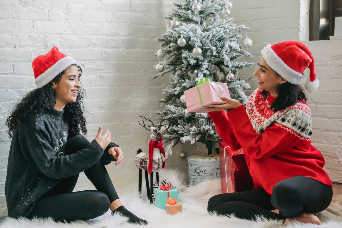 A lady giving gift to her friend on the eve of Christmas