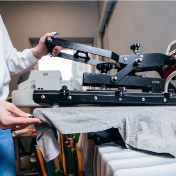 A lady printing a design on the best quality printed T-shirts , ensuring high-quality results for every design.