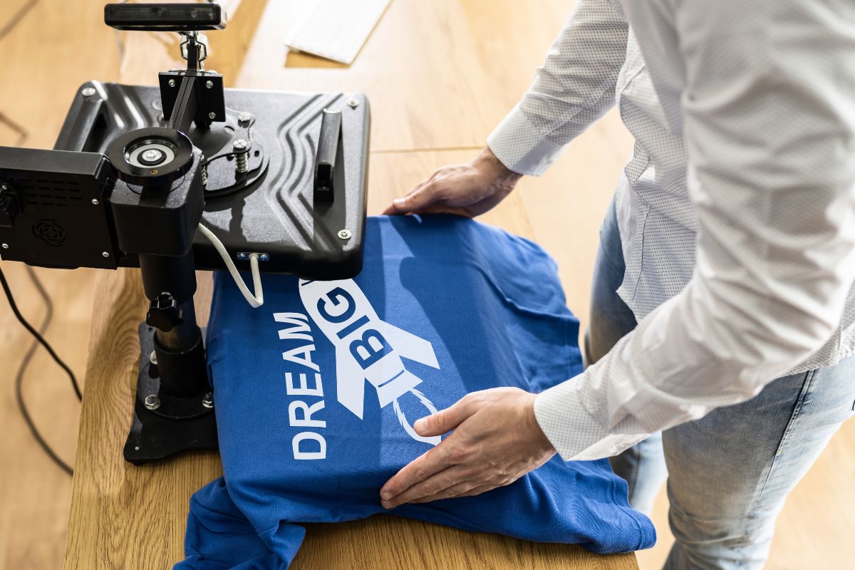 A person printing t-shirt under a heat press machine