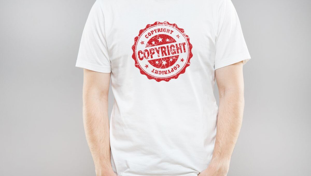 A person wearing a t-shirt with a copyright sign on it, illustrating that t-shirt designs can be protected