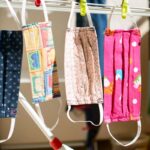A collection of different custom printed face mask hanged together