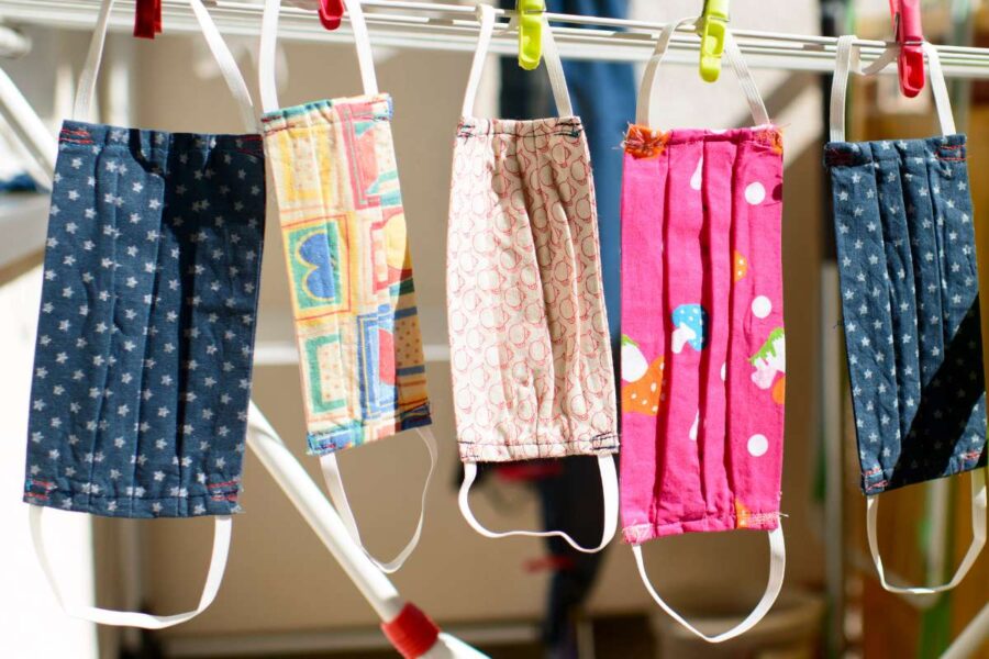 A collection of different custom printed face mask hanged together