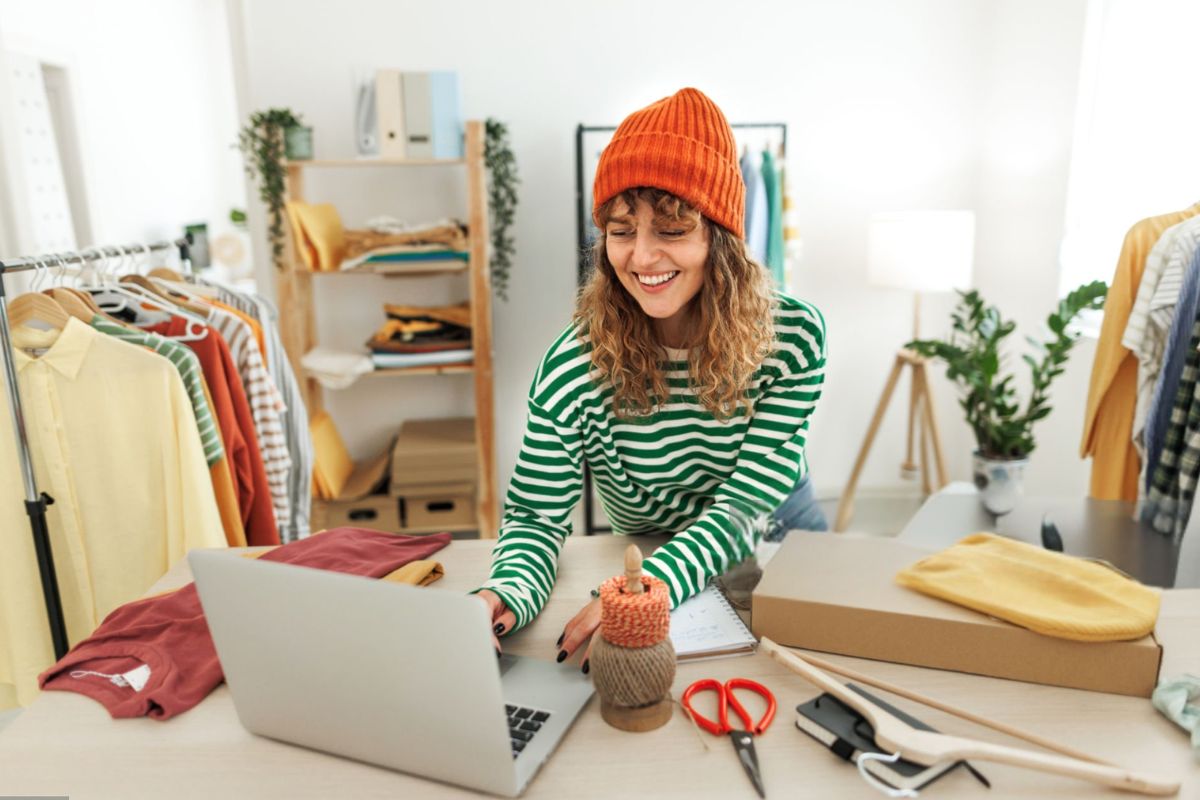A lady selling beanie and other clothing products online