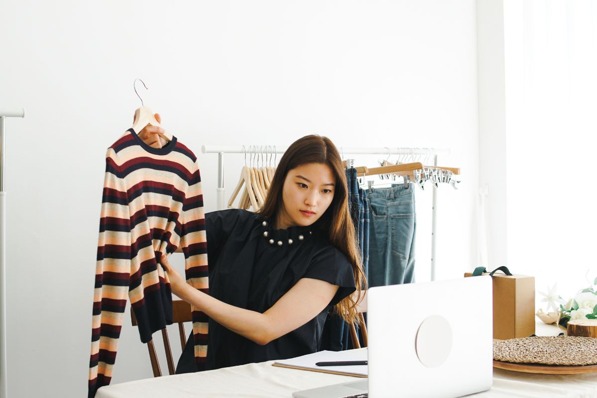 A lady selling crewneck sweatshirt for women and other clothing items online