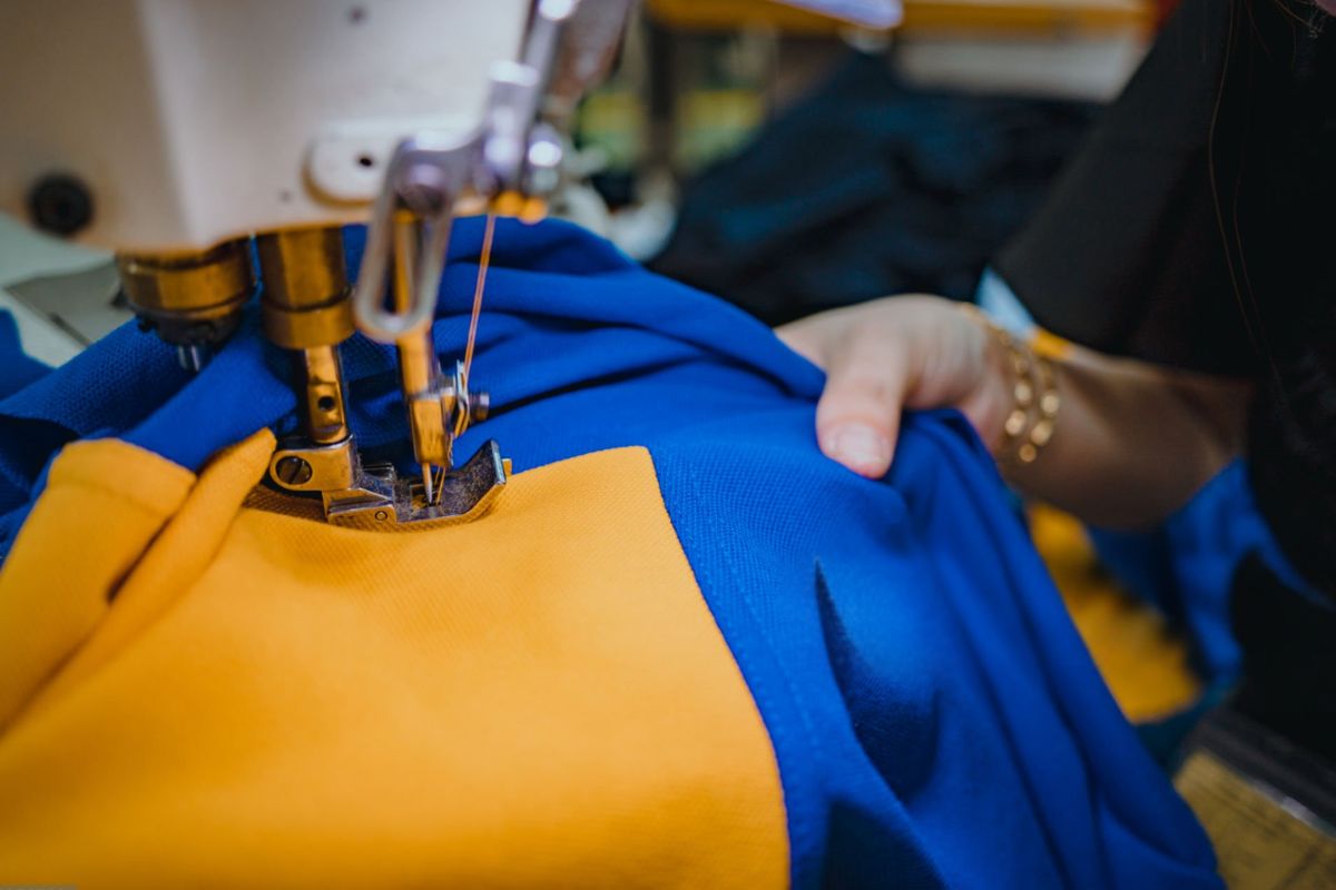 A lady sewing a varsity jacket