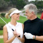 A lady wearing a personalized golf visor while playing golf with her husband