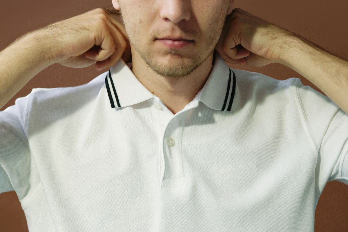 A person checking the fit of his polo T-shirt