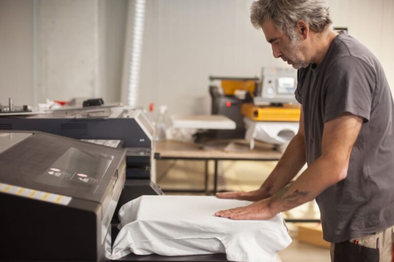 A person doing custom T-Shirt Printing on a machine