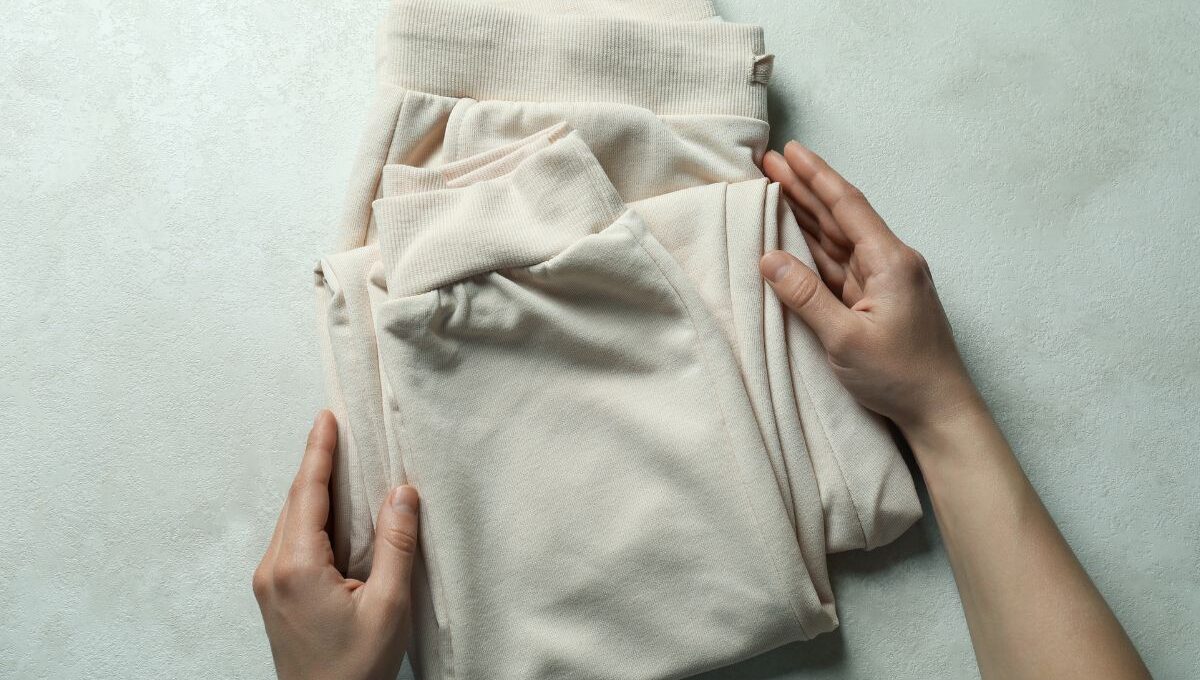 A person folding custom printed sweatpants