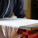 A person printing custom design on sleeveless T-Shirts