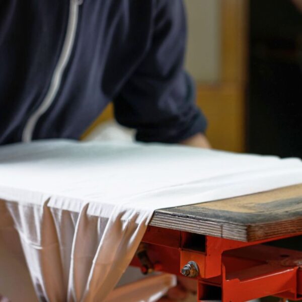 A person printing custom design on sleeveless T-Shirts