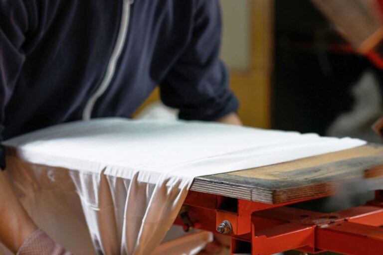 A person printing custom design on sleeveless T-Shirts