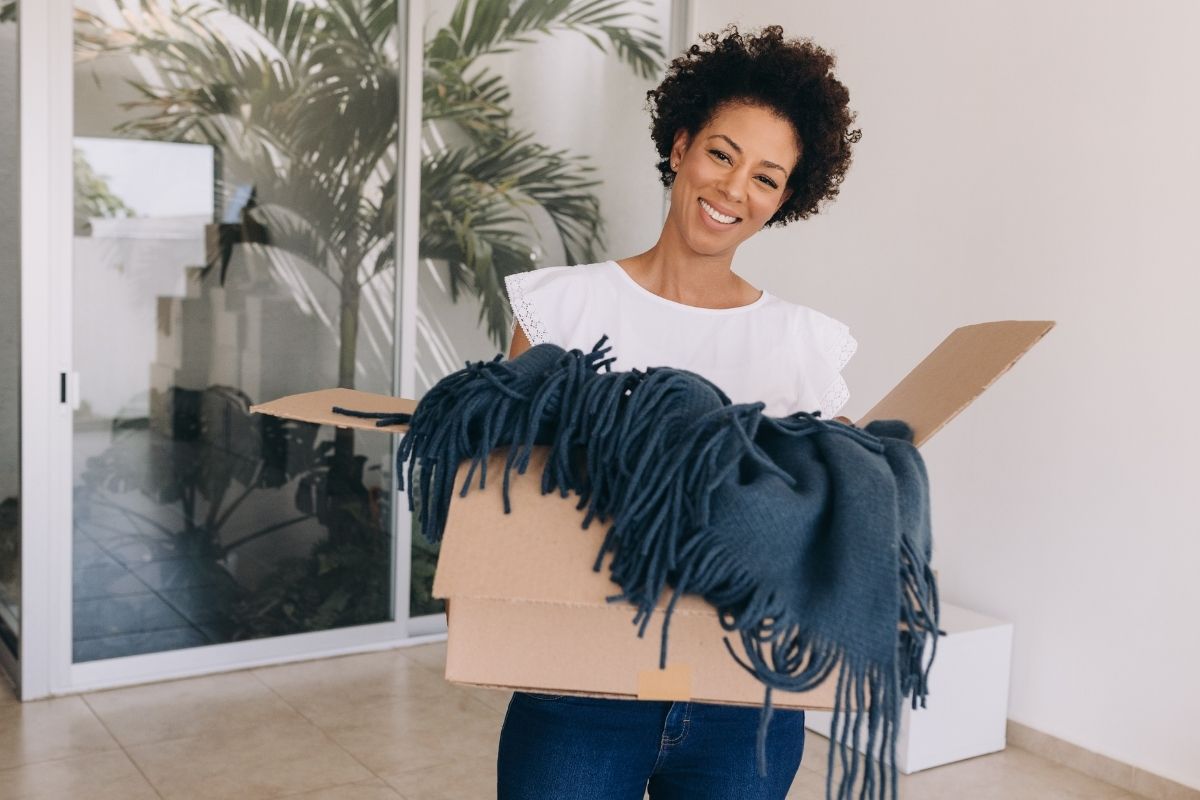 A lady smiling with joy after getting her custom throw blanket delivered