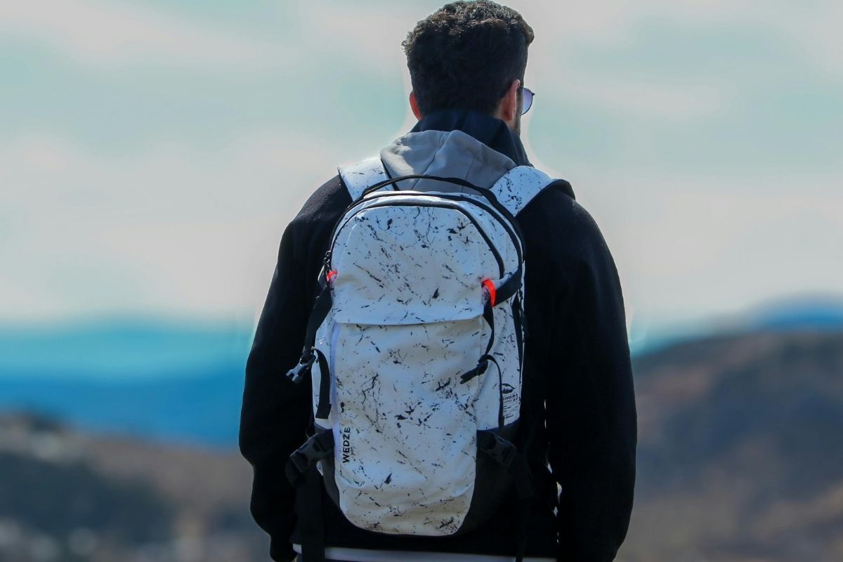 A person wearing embroidered hiking backpack