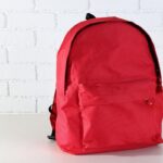 The image shows a red-colored school bag that can be customized