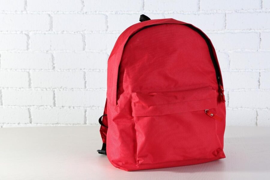 The image shows a red-colored school bag that can be customized
