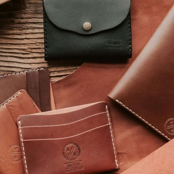 A collection of different custom men's leather wallets is shown in the image