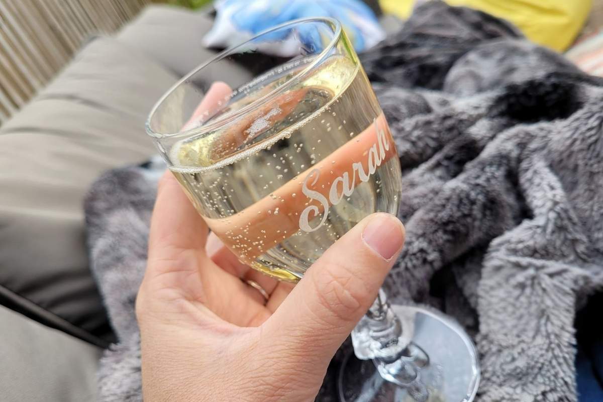 A lady holding her personalized wine glass with her name engraved on it