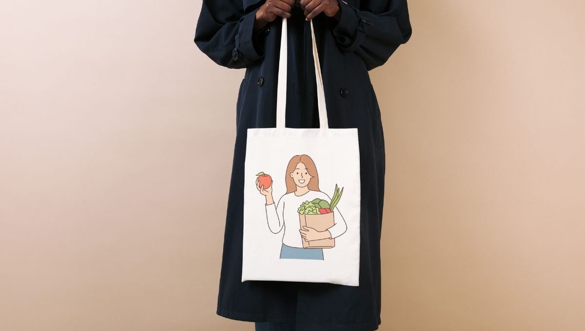 A lady is holding a grocery tote bag