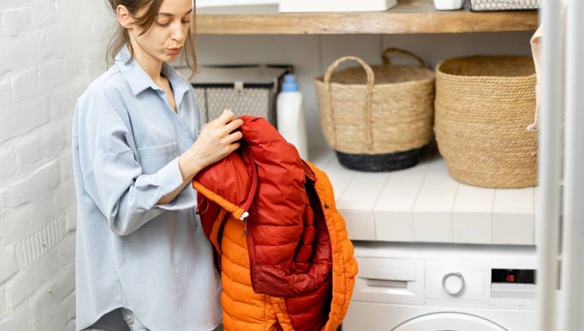 A lady reading the washing instructions on her boyfriend’s puffer jacket