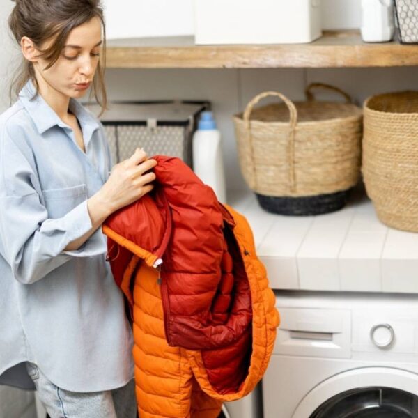 A lady reading the washing instructions on her boyfriend’s puffer jacket