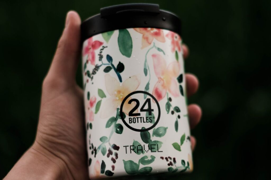 A person holding a custom printed travel mug