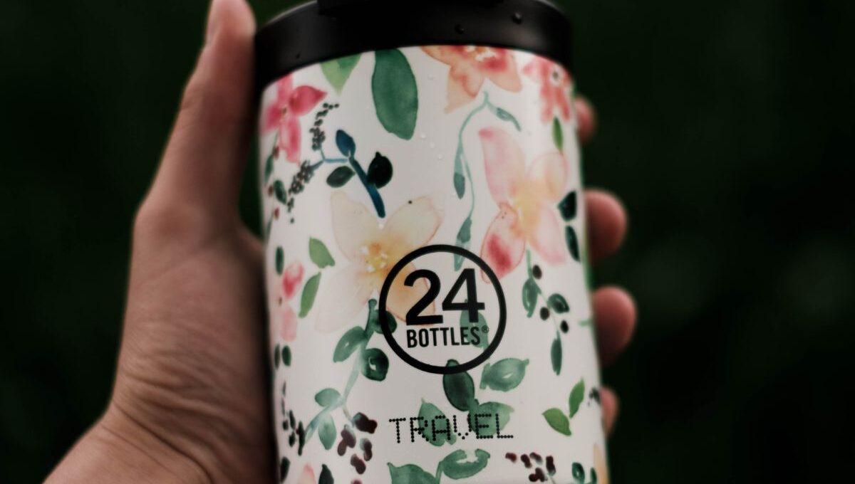 A person holding a custom printed travel mug