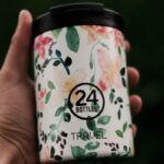 A person holding a custom printed travel mug