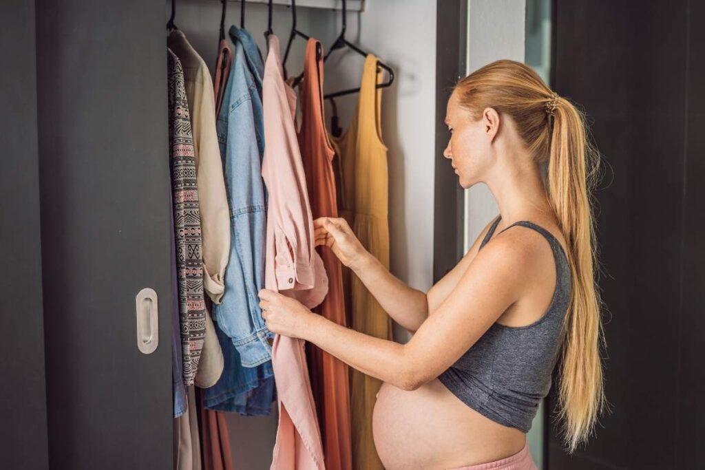A pregnant woman choosing best maternity summer outfits