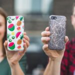 Two friends showing their personalized phone cases